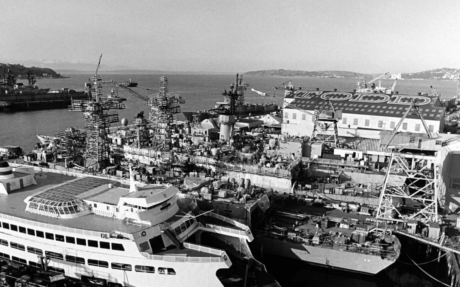 Industrial shipyard showing vessel under construction with framework and work areas visible