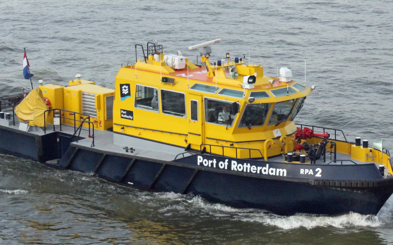 Industrial port waterfront with moored patrol boat and harbor structures visible along the waterside